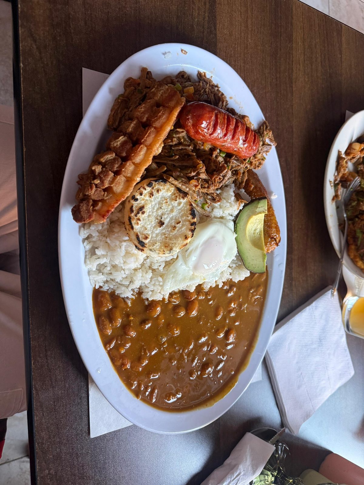 Colombian platter with grilled meats, rice and beans